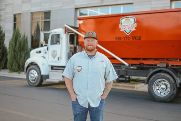 Dumpsters Done Right team member with the company truck and orange dumpster